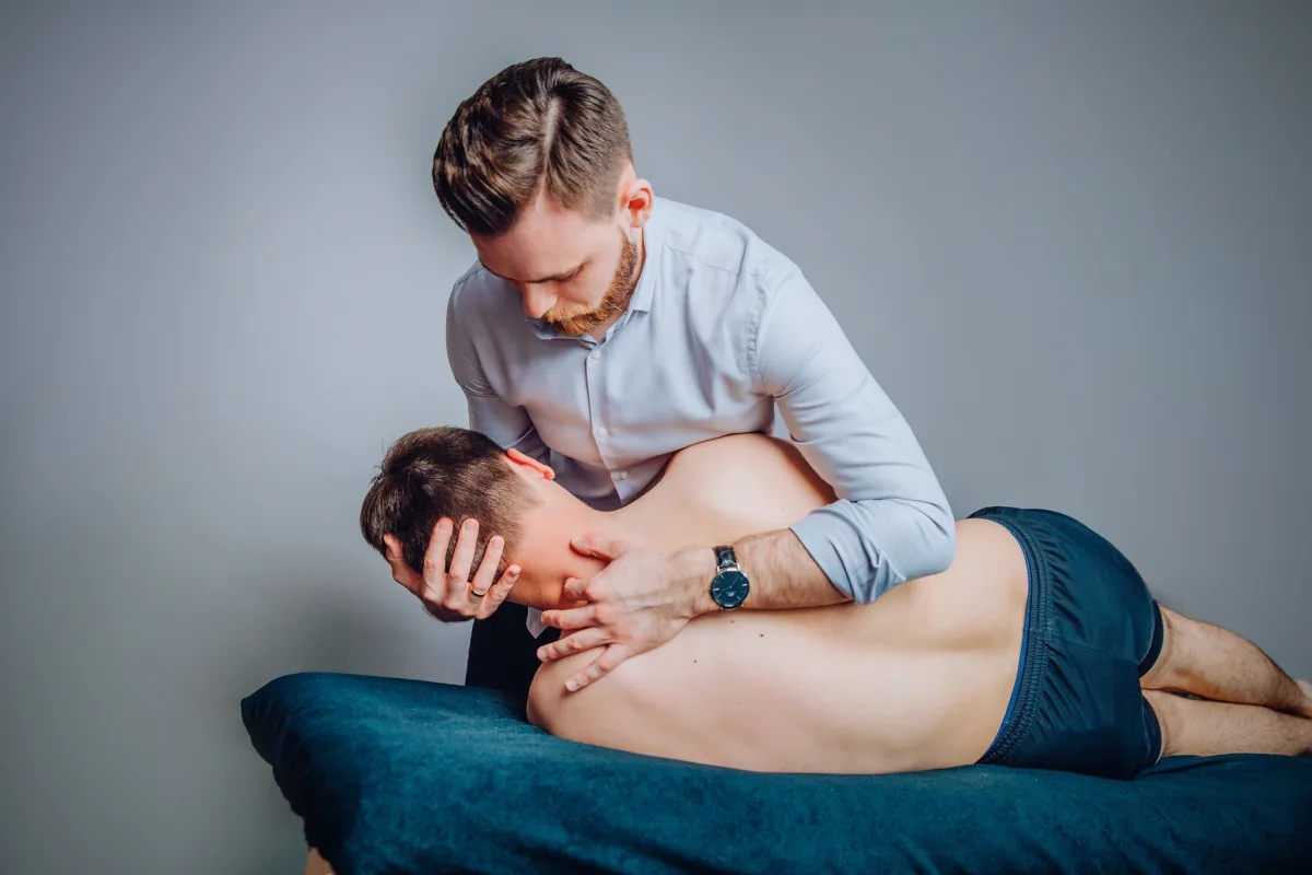 Praca dłoni fizjoterapeuty podczas terapii manualnej szyi i obręczy barkowej